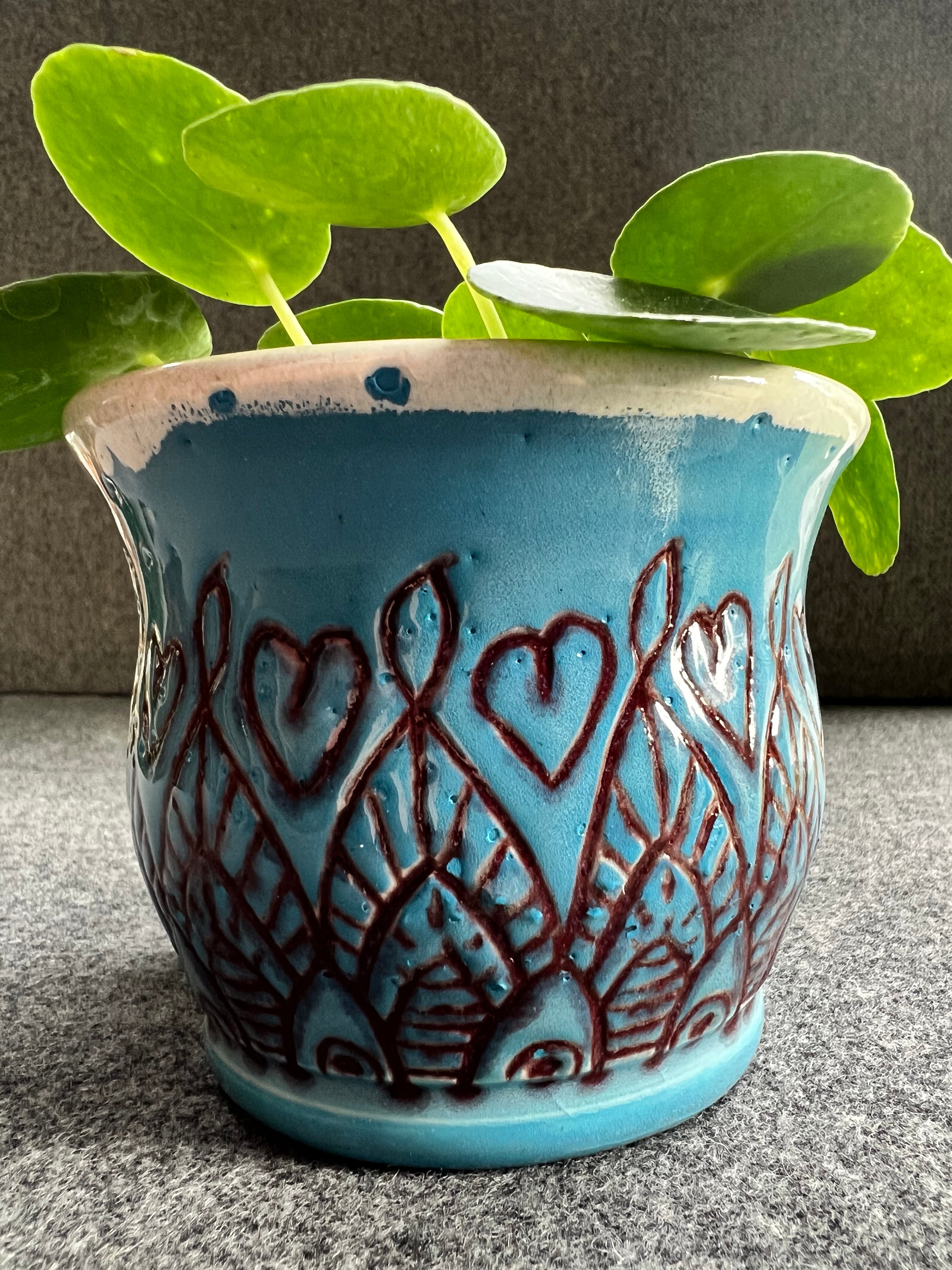 Beautifully crafted blue pot featuring a unique red design.