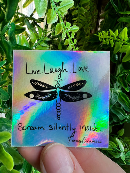 A long-lasting 2x2 Square Holographic sticker featuring live laugh love scream silently music by Ferny Ceramics.