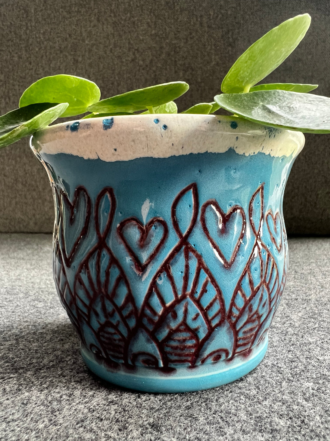 Beautifully crafted blue pot featuring hearts and a unique red design.